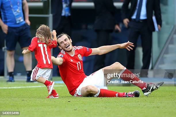 Gareth Bale of Wales celebrates the victory with his daughter Alba Bale on the pitch following the UEFA EURO 2016 round of 16 match between Wales and...