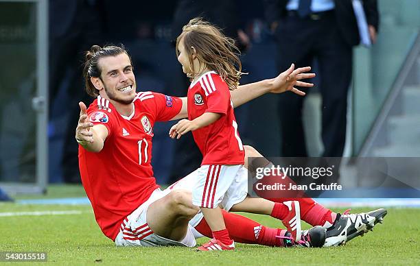 Gareth Bale of Wales celebrates the victory with his daughter Alba Bale on the pitch following the UEFA EURO 2016 round of 16 match between Wales and...