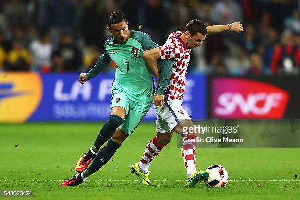 Darijo Srna of Croatia controls the ball under pressure of Cristiano Ronaldo of Portugal during the UEFA EURO 2016 round of 16 match between Croatia...