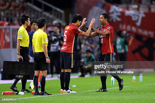 Takeshi Aoki high fives with Boeno during the J.League match between Kashima Antlers and Avispa Fukuoka at the Kashima Soccer Stadium on June 25,...