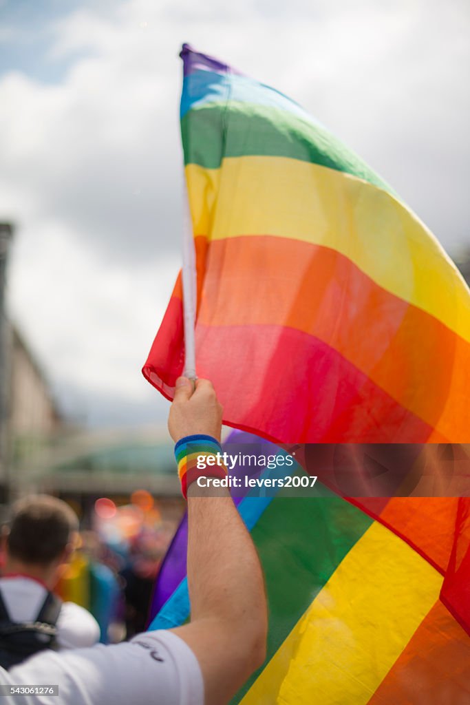 Bandeira do orgulho homossexual de arco-íris e pulseira em Pride Parade