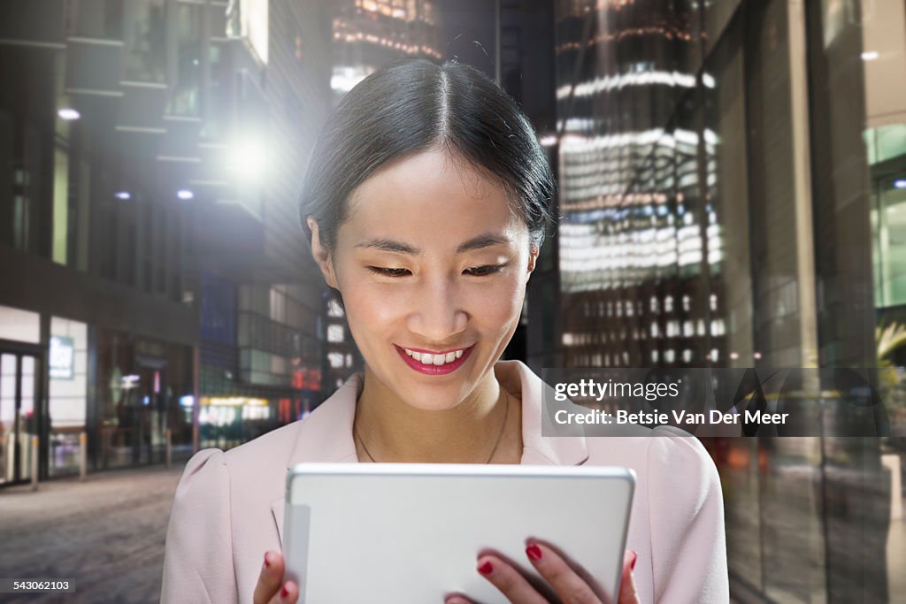 Asian business woman looks at digital tablet.