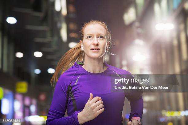 woman jogging in urban street at night. - street running bildbanksfoton och bilder