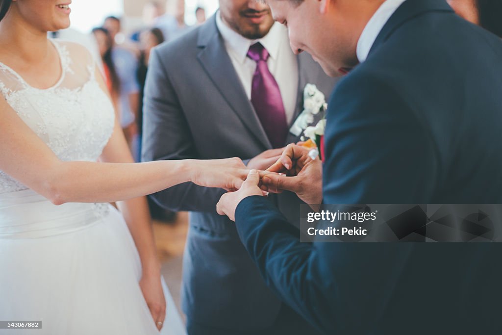 Wedding couple on their ceremony changing their wedding rings