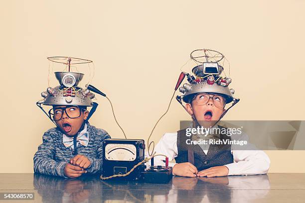 two boys dressed as nerds experimenting with mind reading helmets - stress test stockfoto's en -beelden