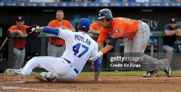 Carlos Gomez of the Houston Astros dives as he tries to score against Peter Moylan of the Kansas City Royals on a wild pitch in the third inning at...