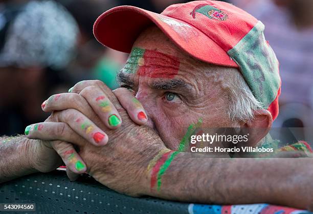 Portuguese supporter prays for the national soccer team victory while watching it playing against Croatia for Eighth-finals of UEFA Euro 2016 on a...