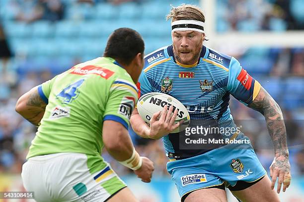 Chris McQueen of the Titans takes on the defence during the round 16 NRL match between the Gold Coast Titans and the Canberra Raiders at Cbus Super...