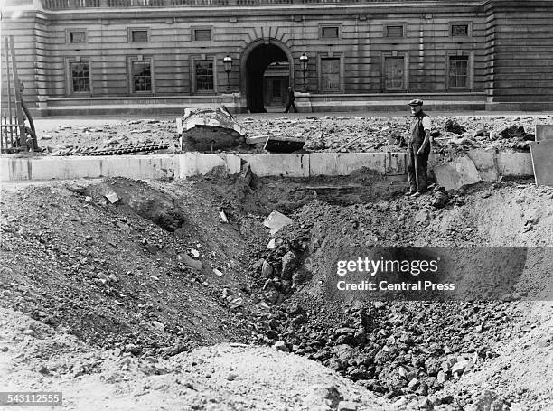 Crater and damaged railings outside Buckingham Palace, London, after the explosion of a German bomb dropped in an air raid the previous day.