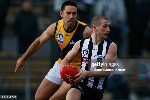 Lachlan Ferguson of the Magpies breaks away from Troy Chaplin of the Tigers during the round 12 VFL match between the Collingwood Magpies and the...