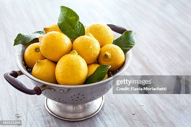 fresh organic lemons on strainer - colander stock pictures, royalty-free photos & images