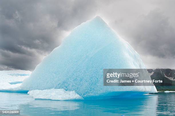 triangular iceberg on gloomy day, bear lake, kenai fjords national park, alaska. - iceberg ice formation stock pictures, royalty-free photos & images