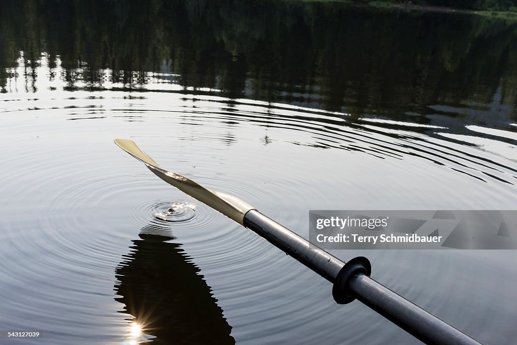 An oar hanging over lake