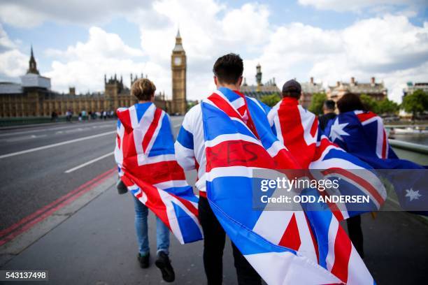 People walk over Westminster Bridge wrapped in Union flags, towards the Queen Elizabeth Tower and The Houses of Parliament in central London on June...