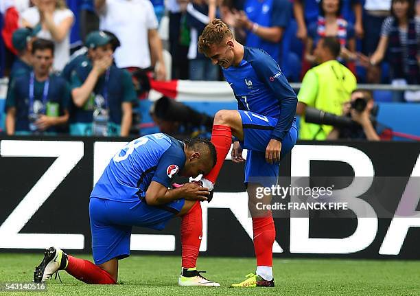 France's forward Dimitri Payet kisses the shoe of France's forward Antoine Griezmann after he scored during the Euro 2016 round of 16 football match...