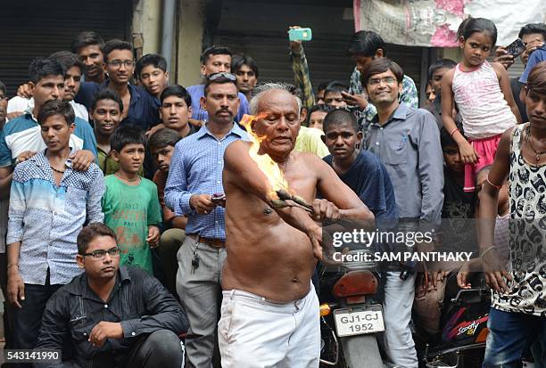 An elderly Hindu devotee rubs fire on his body during a rehearsal for the forthcoming annual Rathyatra festival in Ahmedabad on June 26, 2016. The...