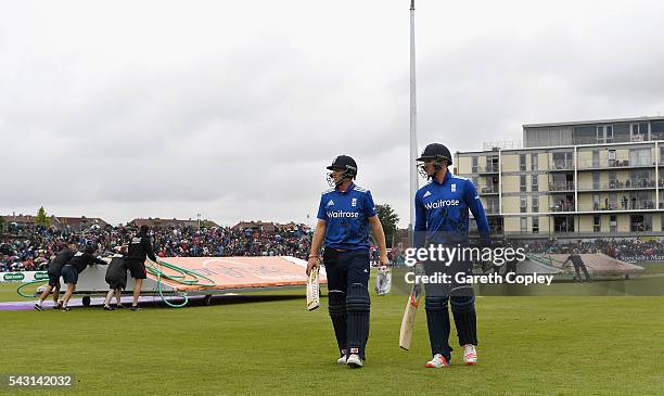 Joe Root and Jason Roy of England leave the field as rain stops play during the 3rd ODI Royal London One Day International match between England and...
