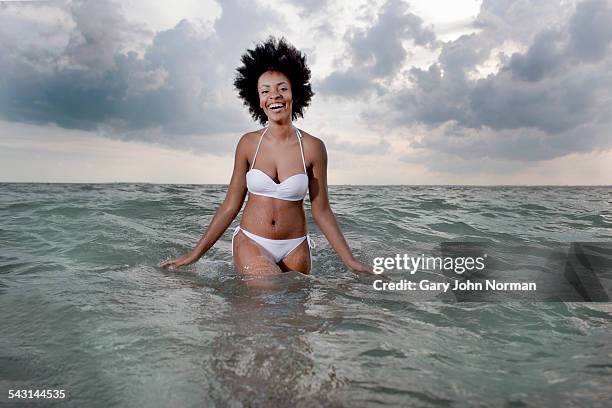 young black woman walking out of ocean - waist deep in water stock pictures, royalty-free photos & images