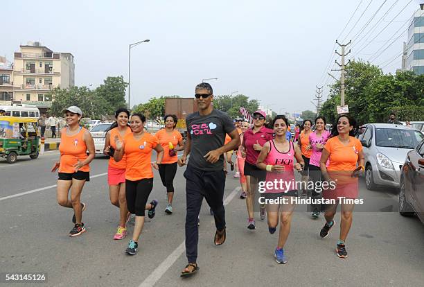 India model-actor-runner Milind Soman with more than 100 women participants takes part during a Pinkathon, touted as India's biggest women's run, on...