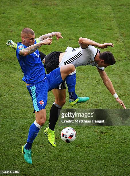 Mario Gomez of Germany and Martin Skrtel of Slovakia compete for the ball during the UEFA EURO 2016 round of 16 match between Germany and Slovakia at...