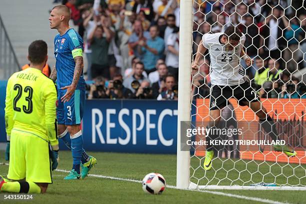 Germany's forward Mario Gomez celebrates next to Slovakia's goalkeeper Matus Kozacik and Slovakia's defender Martin Skrtel after scoring a goal...