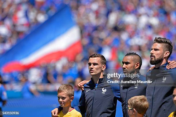 Antoine Griezmann, Dimitri Payet, Olivier Giroud of France react during the national anthem before the UEFA Euro 2016 round of 16 match between...