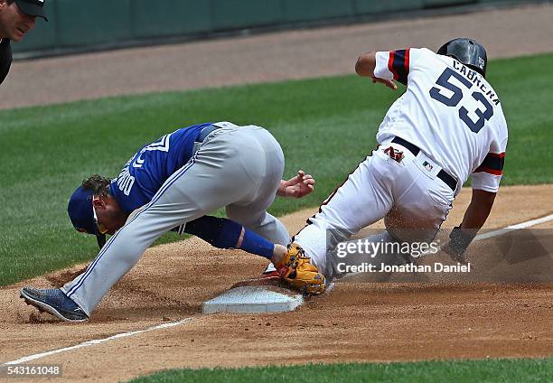 Melky Cabrera of the Chicago White Sox appears to safely slide into third base as Josh Donaldson of the Toronto Blue Jays attempts to make the tag...