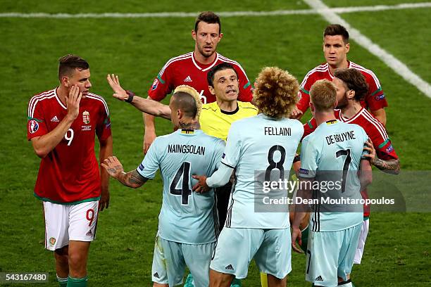 Referee Milorad Mazic and players try to separate argued Adam Szalai of Hungary and Marouane Fellaini of Belgium during the UEFA EURO 2016 round of...