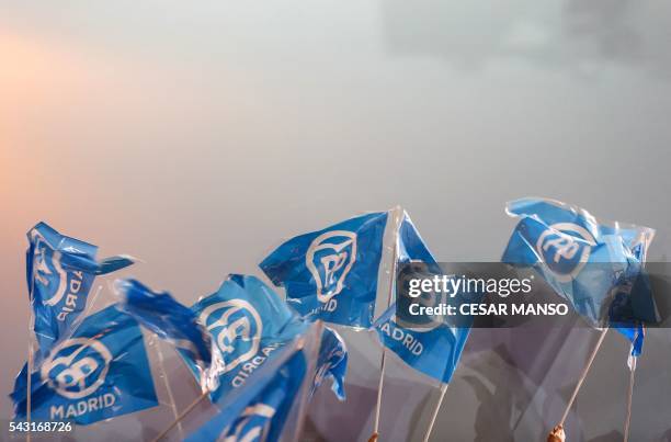 Supporters of the Popular Party wave flags as they wait for results outside the PP headquarters during Spain's general election in Madrid on June 26,...