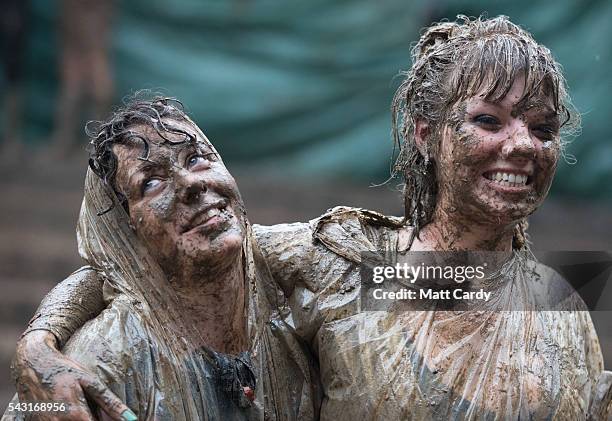 Two festival goers roll in the mud after they took part in a tomato fight at the Glastonbury Festival 2016 at Worthy Farm, Pilton on June 25, 2016...