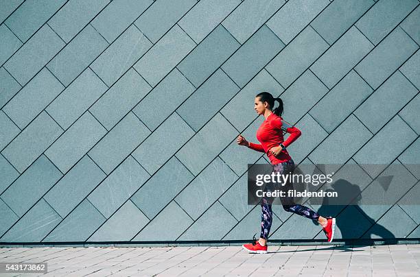 jogging in der stadt - red shirt stock-fotos und bilder