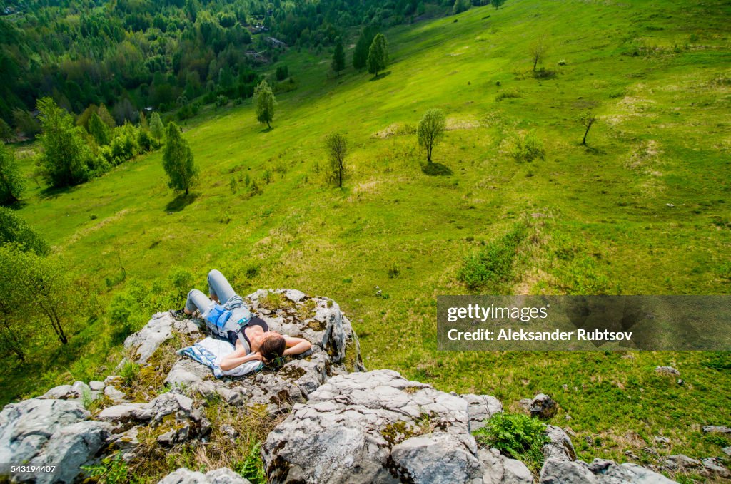 High angle view of Caucasian girl laying on cliff edge