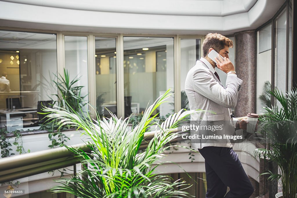 Caucasian businessman talking on cell phone on office balcony