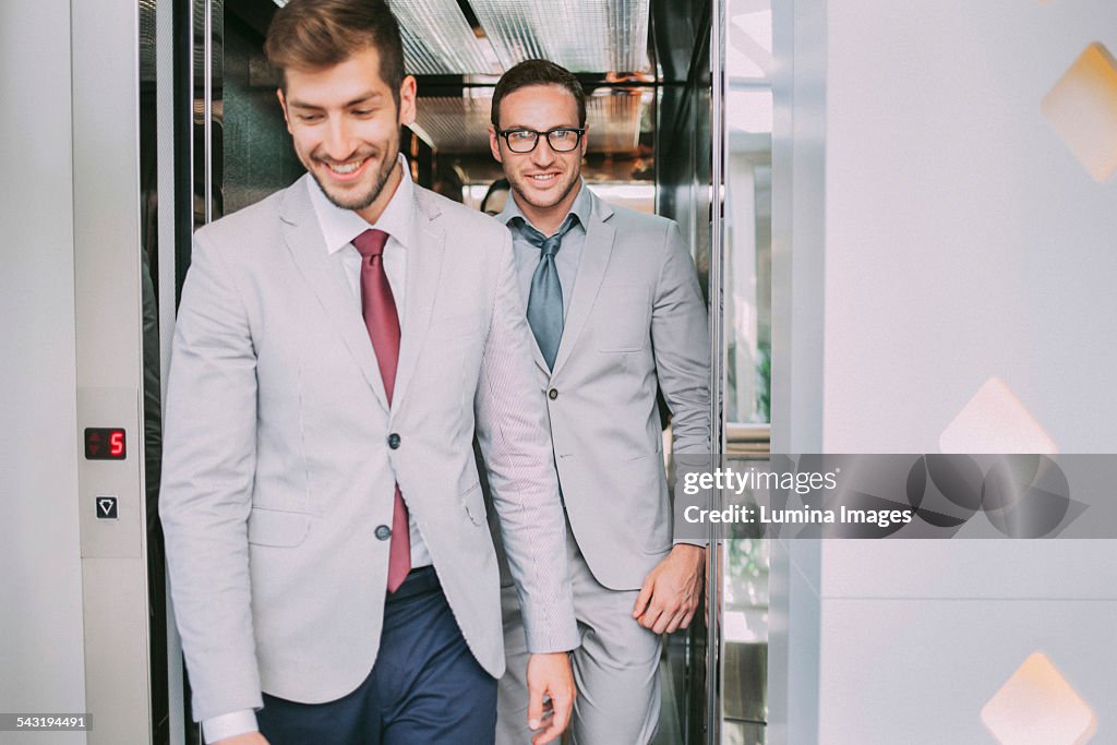 Caucasian businessmen walking out of elevator