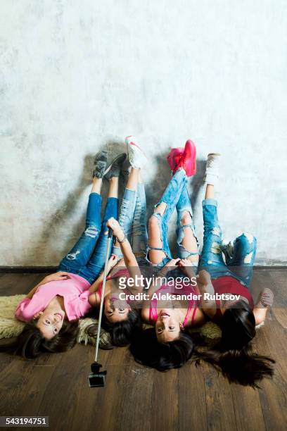 caucasian women taking cell phone selfie on floor - feet selfie woman stockfoto's en -beelden