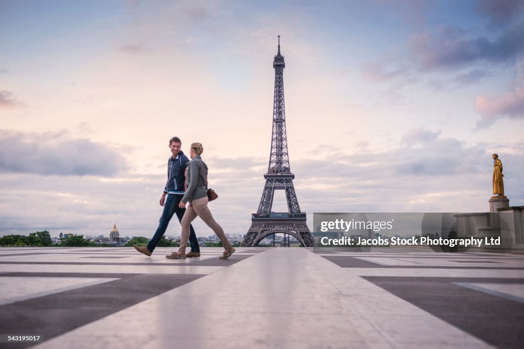 Caucasian couple walking near Eiffel Tower, Paris, France