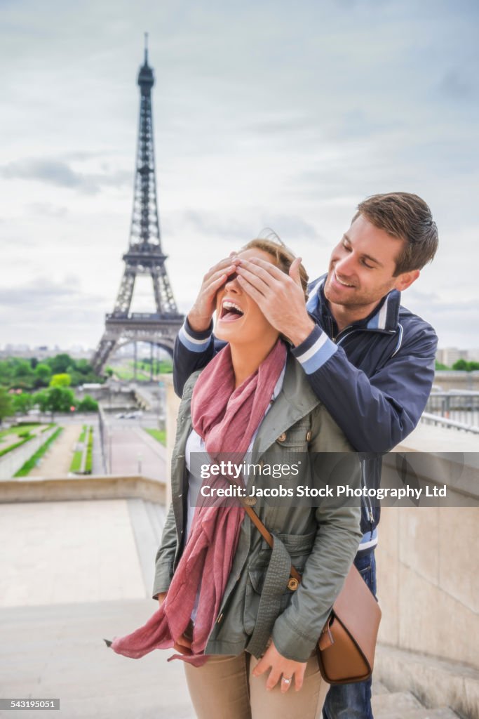 Caucasian couple playing near Eiffel Tower, Paris, France