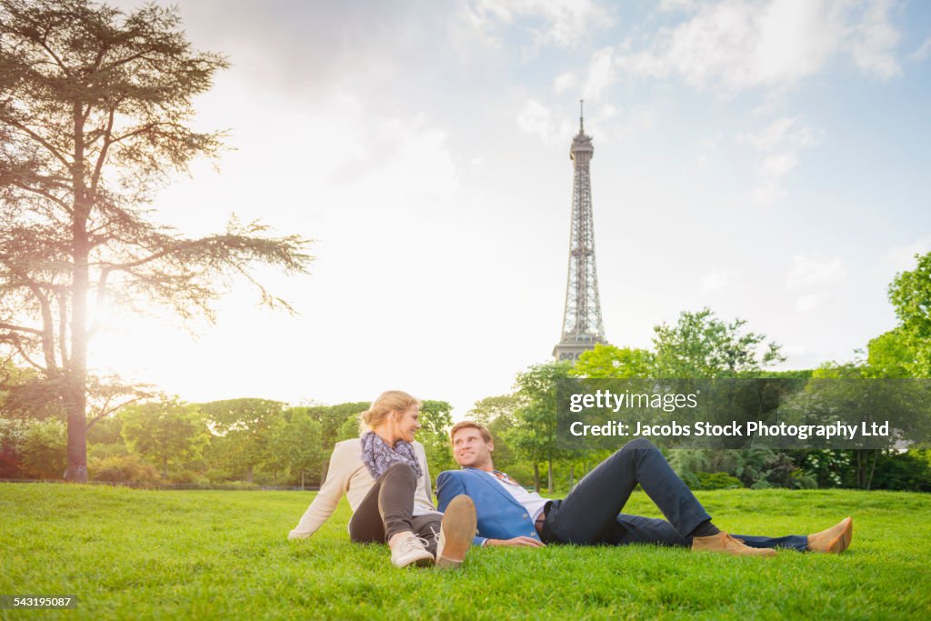 Caucasian couple relaxing in park near Eiffel Tower, Paris, France