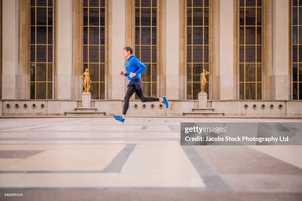 Caucasian man running in courtyard