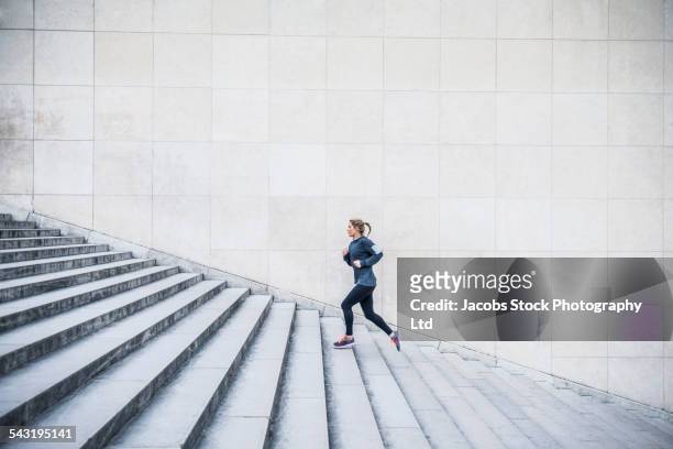 caucasian woman running up staircase - staircase imagens e fotografias de stock