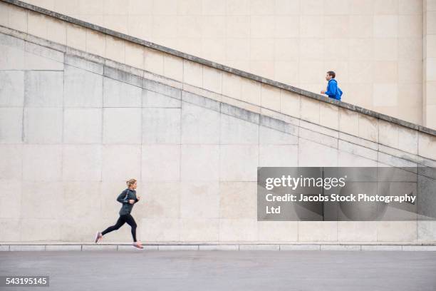 runners jogging near staircase - training center stock-fotos und bilder