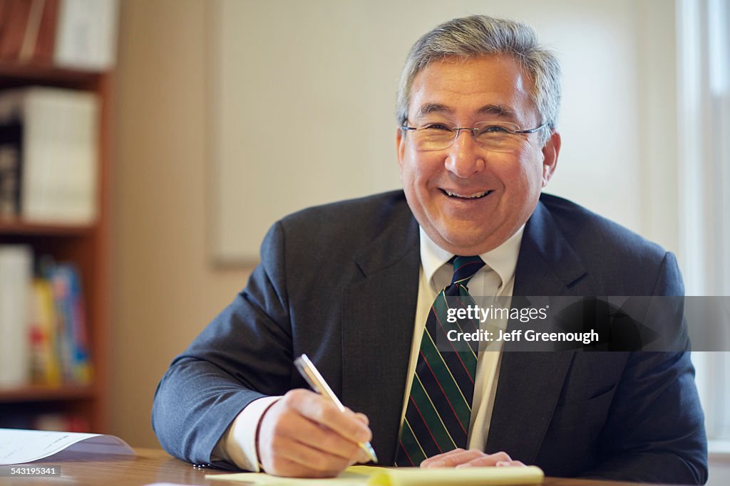 Mixed race businessman smiling at desk in office