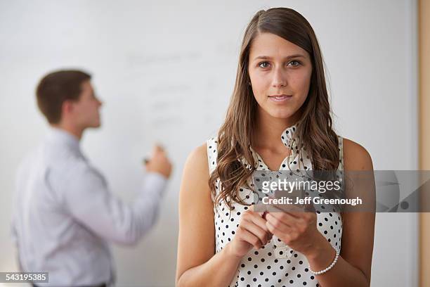 mixed race businesswoman using cell phone in office - blacksburg stock pictures, royalty-free photos & images