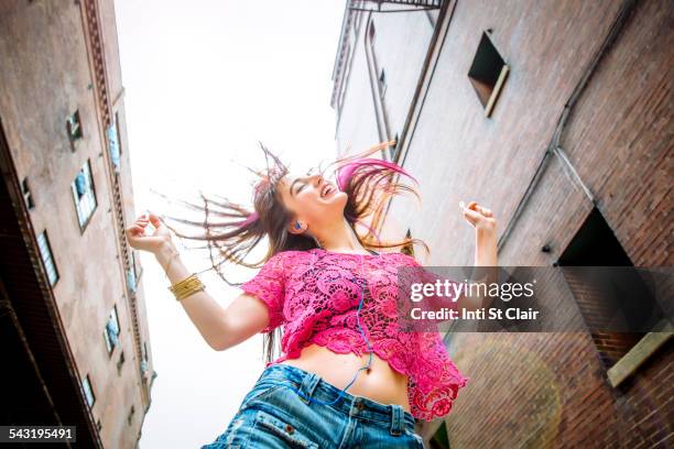 low angle view of caucasian woman dancing outdoors - swing tanz stock-fotos und bilder