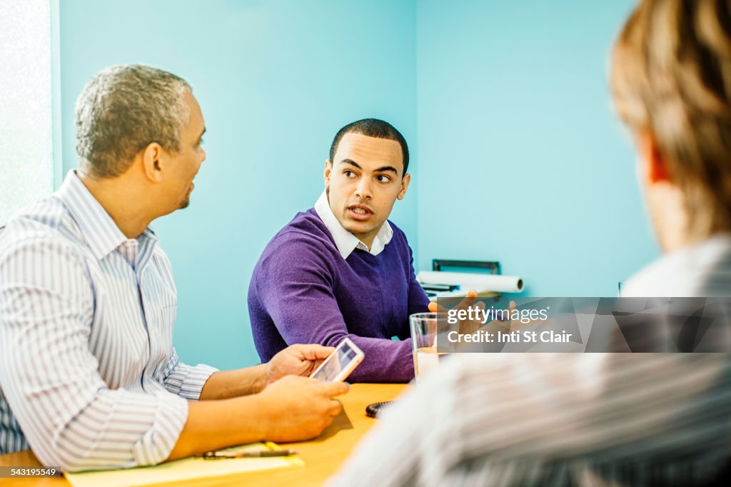 Businessmen talking in office meeting