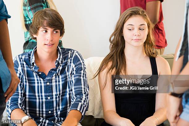 awkward curious teenage couple at party - ashamed stock pictures, royalty-free photos & images