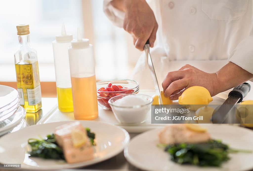 Korean chef slicing lemons in kitchen