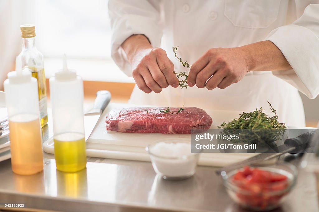 Korean chef seasoning meat in kitchen