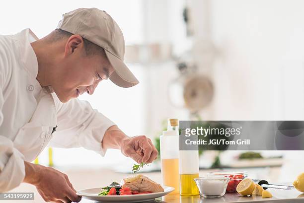 korean chef preparing meal in kitchen - uniforme de chef fotografías e imágenes de stock