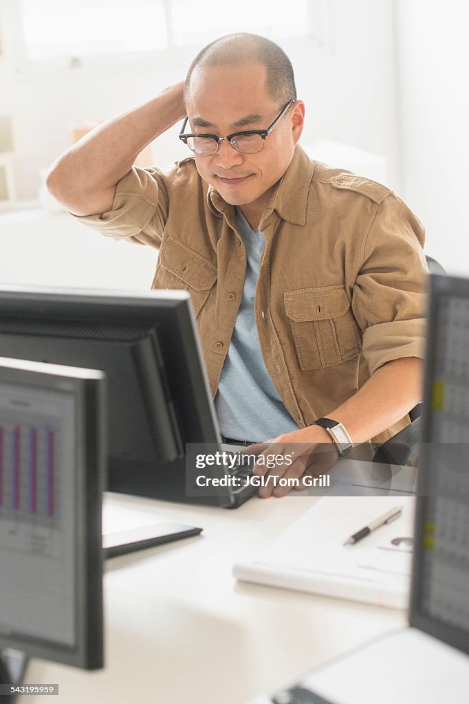 Korean businessman working on computer at office desk